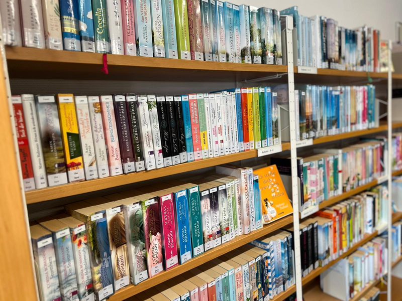 Ein Bücherregal aus der Bücherei in Horgenzell mit vielen bunten Bücher darin.